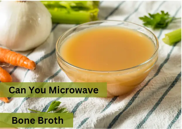 a bowl of bone broth next to carrots and celery on a cloth